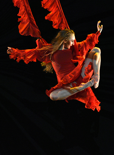 Image of a dancer leaping in a red flowing garment