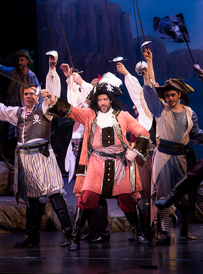 Image of actors dressed in pirate costumes singing on stage